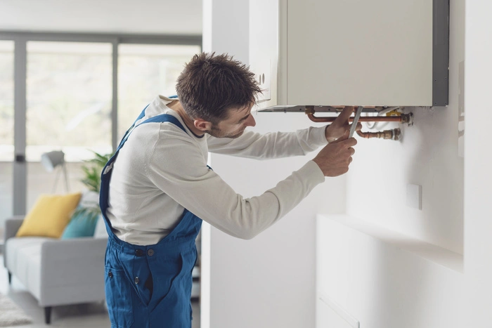 Professional plumber checking a boiler and pipes, boiler service concept