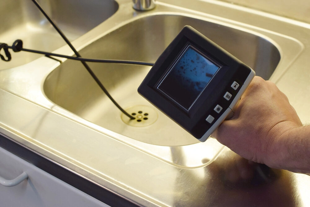 Checking drain pipe with borescope inspection camera.