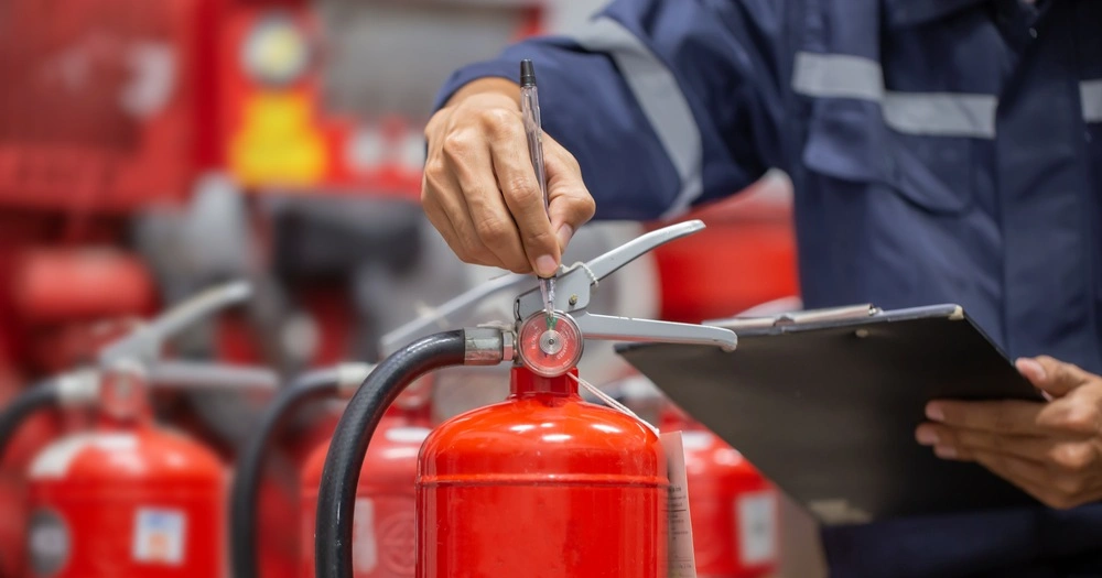 Engineer are checking and inspection a fire extinguishers tank in the fire control room for safety training and fire prevention.